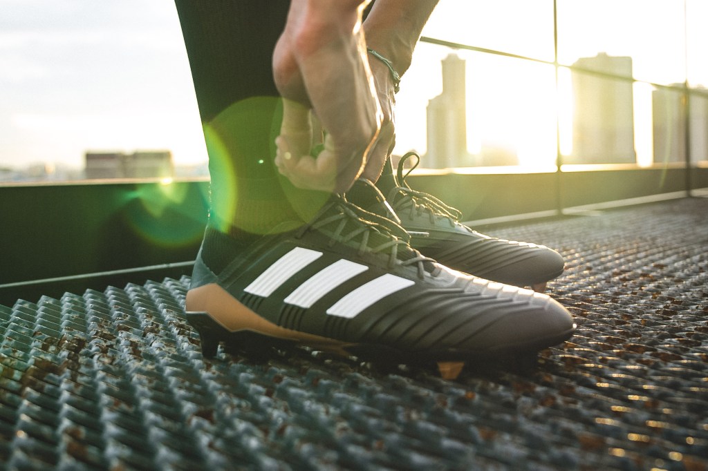 An image of someone's sports shoes. They are tying their shoelaces.